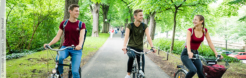 Studierende fahren auf Fahrrädern einen Radweg entlang